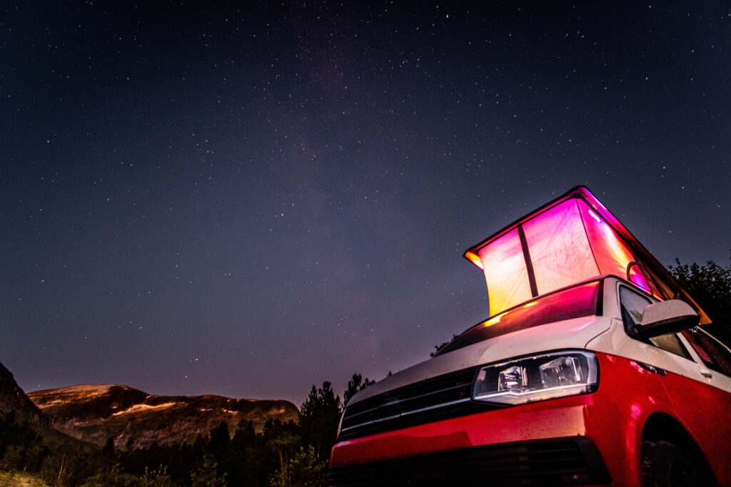 Campervan with Skyline pop top roof lit up at night
